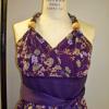 A purple satin halter dress with a floral organza overlay and matching sash.