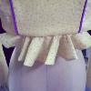 A pale yellow cotton spencer with puffed sleves and hand made purple piping.  This image highlights the ruffled peplum center back.