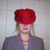 A red felt fedora was steamed and reshapen to mimic styles similar to those found in the 1880's and 1890's.  The hat has been adorned with a plum colored bias tape and burgundy flowers.