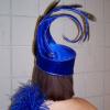 Black buckram hat stablized with milinary wire.  Covered in baby flannel and then royal blue satin.  Adorned with silver cording, rhinestones, and peacock feathers.